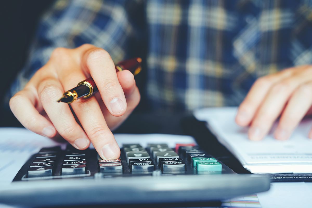 Calculadora e papéis sobre a mesa para comparar valores de plano de saúde