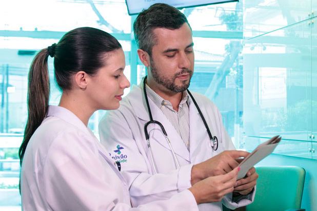 Profissionais de saúde conferindo informações em tablet