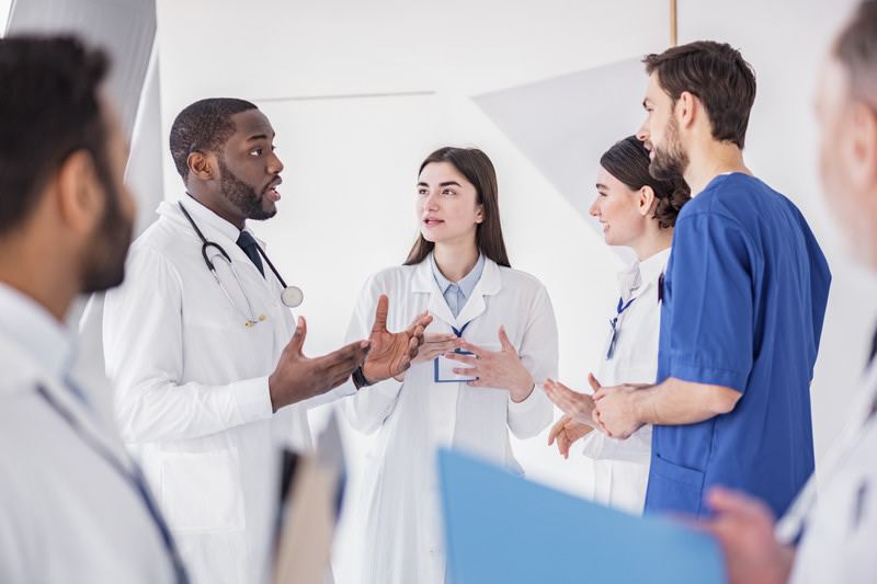 Equipe médica conversando em corredor de hospital